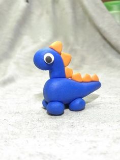 a blue toy with an orange beak sitting on a white surface