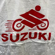 a white t - shirt with the word suzuki written in red on it