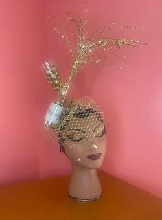 Get reasy to pop bubbles with excitement over this stunning headpiece.  Whether you're toasting the town or ringing in the New Year, this headband style fascinator headpiece is perfect for you. It's glamorous and whimsical, capturing the golden moment with champagne pops out the bottle. Bottle and glass are made of plastic and are filled with faux bubbly in gold. The hand sewn felt base is trimmed in gold braid trim and features a ribbon wrapped metal headband to hold it in place perfectly.  For Mardi Gras Party Crown Headpiece, Whimsical Crown Headpiece For Party, Whimsical Crown Headband For Parties, Whimsical Tall Crown Costume Hat For Party, Adjustable Gatsby Style Party Hair Accessories, Adjustable Gatsby Style Hair Accessories For Party, Adjustable Crown Costume Hat For Party, Whimsical Crown Hair Accessories For Parties, Vintage Gold Headband For Party