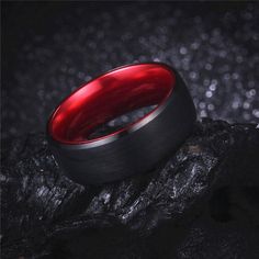 a red ring sitting on top of a rock