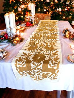 a decorated table with candles and christmas tree in the backgroung area,