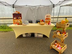 a table set up with baskets and food on it in front of a white tent