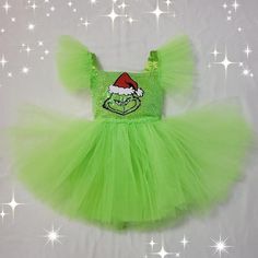 a green tutu skirt with a grin face on the front and santa hat on top