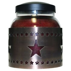 a red candle in a metal jar with stars on it