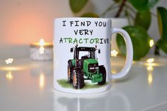 a coffee mug that says i find you very attractive with a tractor in the background