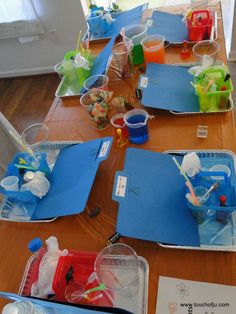 the table is set up with plastic cups and other items to make an art project