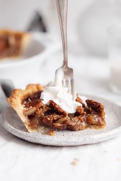 a slice of pecan pie on a plate with a fork sticking out of it