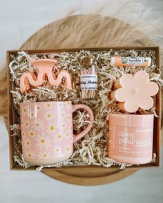 a pink coffee cup and two mugs in a gift box with flowers on it