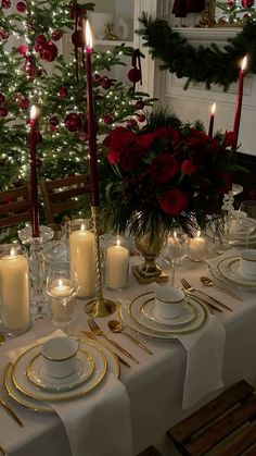 a table set for christmas dinner with lit candles