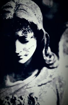 a black and white photo of a woman's face covered in mud, with her eyes closed