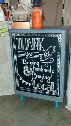 a chalkboard sign on top of a metal cabinet with writing on the front and bottom