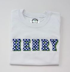 Checkered font Embroidered T-shirt, custom colors available upon request. This listing is for one embroidered T-Shirt. All items are made to order. I do my best to accurately portray the fabric and thread colors, but there may be slight variations based on lighting and computer screen settings.  Care instructions:  Machine wash inside out in cold water on delicate setting. Hang dry is recommended. Returns: Due to the nature of custom items, I do not accept returns. If there is a mistake of defect with the garment, please contact me in a timely manner of receiving the item, and I will provide a solution. Green Crew Neck T-shirt With Custom Embroidery, Casual T-shirt With Multicolor Letter Embroidery, Casual Multicolor Embroidered Letter T-shirt, Multicolor Embroidered Text Crew Neck T-shirt, White Embroidered Text Crew Neck Shirt, White Crew Neck Shirt With Embroidered Text, White Crew Neck Shirt With Embroidered Logo, White Cotton Shirt With Embroidered Text, Green Short Sleeve T-shirt With Custom Embroidery