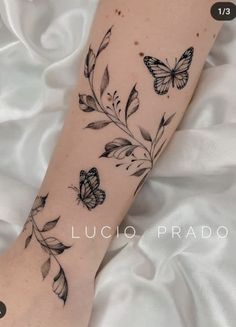 a black and white photo of a butterfly tattoo on the left arm, with butterflies all over it