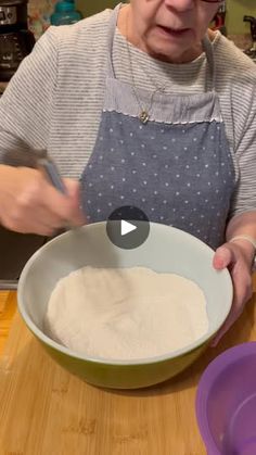 an elderly woman mixing flour in a bowl