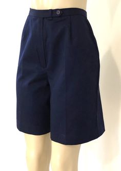 "Vintage 1980s navy blue dress / walking shorts by Izod Lacoste, featuring the iconic crocodile logo, a 1\" band waist, a rear pocket, and front zipper, hook and eye and button closure. Approximate Measurements: Waist: 27\"; Hips: 39\"; Length: 19.5\"; Inseam: 8.5\" Labeled a Size 10 High end shorts, circa 1980s, in excellent vintage condition - likely never even worn. Enjoy! *(International Buyers are welcome - however, please email me so I can check the shipping rate for you before committing Fitted Solid Color Shorts For School, Blue Knee-length Cotton Bermuda Shorts, Blue Cotton Knee-length Bermuda Shorts, Navy Knee-length Bottoms With Pockets, Summer School Uniform Bottoms, Navy Workwear Shorts With Pockets, Navy Shorts With Pockets For Work, Classic Fitted Bermuda Shorts, Fitted Cotton Bermuda Shorts For Work