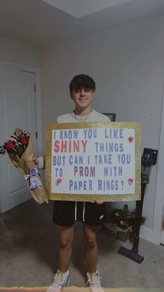 a man holding a sign that says i know you like shiny things but can take you to prom with paper rings?