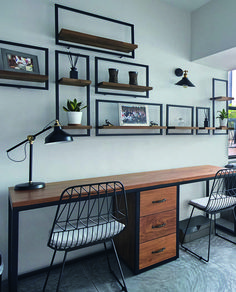 a desk with two chairs and some pictures on the wall