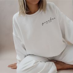 🌟 Our "Grandma Est. 2024" Sweatshirt is more than just clothing; it's a heartfelt expression of the love and joy that comes with the arrival of a new grandchild. Whether you're announcing the news or celebrating this significant life event, this sweatshirt is the perfect choice. Don't miss the chance to commemorate this special moment in style. Add it to your cart today! 🌟 I T E M ∙ D E T A I L S * Crewneck Sweater, 50% cotton, 50% polyester * Unisex Sizing: S, M, L, XL, 2XL, 3XL Care Instructions: Machine wash cold. Tumble dry low or hang to dry. Wash inside out. Do not iron or dry clean. To Make Your Ordering Process Seamless, Please Follow These steps: - Read all the relevant information and review the product photos. - Select the desired t-shirt type and choose your size from the fir White Sweatshirt With Name Print, Relaxed Fit, White Sweatshirt With Name Print And Relaxed Fit, Relaxed Fit White Sweatshirt With Name Print, White Sweatshirt With Lettering For Loungewear, Gift For New Grandma, New Grandchild, Gifts For New Grandma, New Grandma Gift, Grandma Sweatshirt