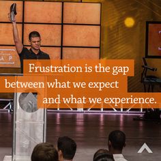 a man giving a speech on stage with an orange and white sign in front of him that says frustration is the gap between what we expect and what we experience