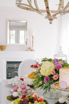 a table topped with plates filled with cake and desserts next to a fire place