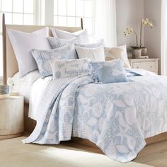 a bed with blue and white comforters in a bedroom