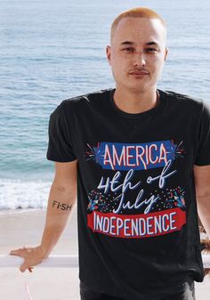 a man standing on the beach with his hands out in front of him and looking at the camera