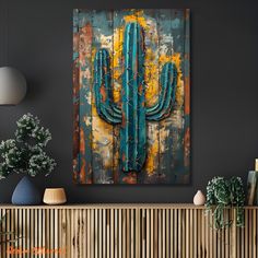 a painting on the wall of a living room with a large cactus in front of it