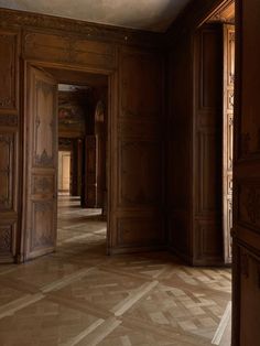 an empty room with wood paneling and walls in the middle is seen from the doorway