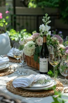 the table is set with wine and flowers