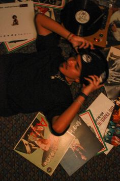 a man laying on the floor next to records