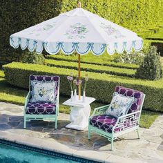 two chairs and an umbrella near a swimming pool