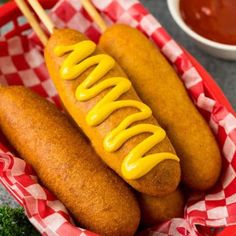 two hotdogs with mustard and ketchup in a basket