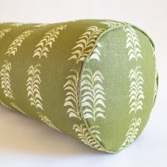 a green and white pillow with leaves on it