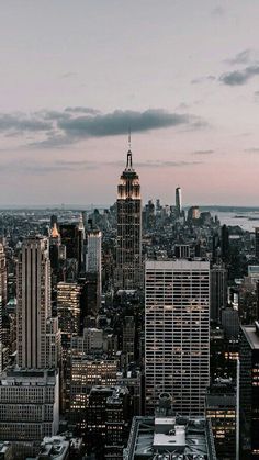 an aerial view of new york city at dusk with the empire building in the foreground