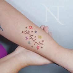 a woman's arm with stars on it and the words happy new year written in different colors