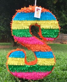 a colorful letter made out of paper on the grass