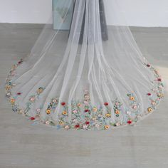 a veil with flowers on it hanging from the ceiling