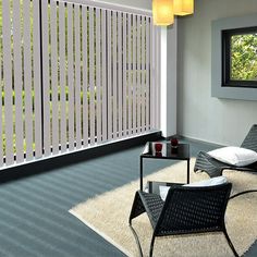 a living room filled with furniture next to a wall covered in vertical slatted blinds