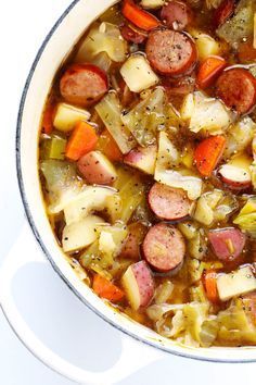 a pot filled with stew and vegetables on top of a table