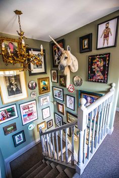 a staircase with pictures on the wall and an animal head