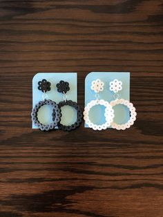 two pairs of earrings sitting on top of a wooden table