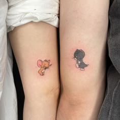 two people with matching tattoos on their legs, one has a cat and the other has a dog