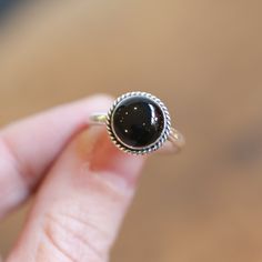 LBJ Pop Rock Ring in Black Agate Everybody loves this Black Agate ring. The black agate stone is always in fashion and always matches! Our Pop Rock Ring lets the 10mm Black Agate be the center of the show! Just right - easy to wear. Enhanced with a simple twist wire, this Black Onyx Ring stands alone or is a fantastic addition to a handful of rings. All .925 Sterling Silver. Choose your size in the drop-down below. All traditional silversmithing is done in our Baltimore Studio. Black Agate 10mm Silver Rings With Black Stones, Black Stackable Rings With Round Band For Gift, Adjustable Black Round Band Jewelry, Everyday Black Onyx Rings, Black Agate Round Ring, Gift Black Agate Ring, Black Gemstone Rings In Sterling Silver, Black Onyx Crystal Ring With Gemstone, Black Sterling Silver Crystal Ring