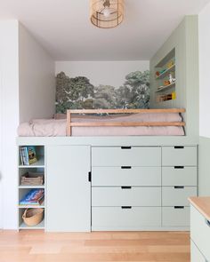 there is a white bed in the corner of this room with drawers on both sides