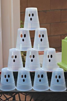 plastic cups with faces are stacked on top of each other in the shape of a pyramid