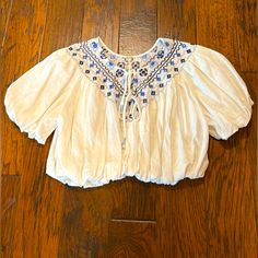 Free People White Embroidered Top, Size Xs. Loose Fit. New, Never Worn. Casual Embroidered Cropped Blouse, Casual Cropped Embroidered Blouse, Embroidered Cropped Tops For Vacation, White Embroidered Cropped Blouse, White Cotton Peasant Embroidered Top, White Peasant Embroidered Top, White Peasant Embroidered Long Sleeve Top, Bohemian V-neck Embroidered Top, Bohemian Embroidered Off-white Blouse