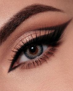 a woman's eye with long lashes and blue eyeshadow