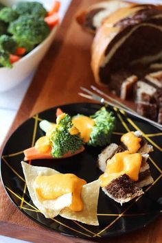 a black plate topped with food next to a bowl of broccoli