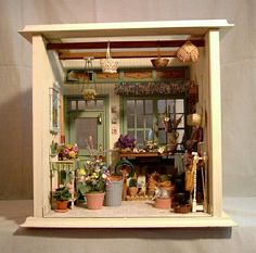 a doll house with lots of pots and pans on the shelf in front of it