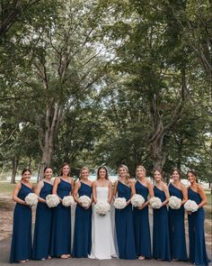 the bride and her bridesmaids pose for a photo in front of some trees